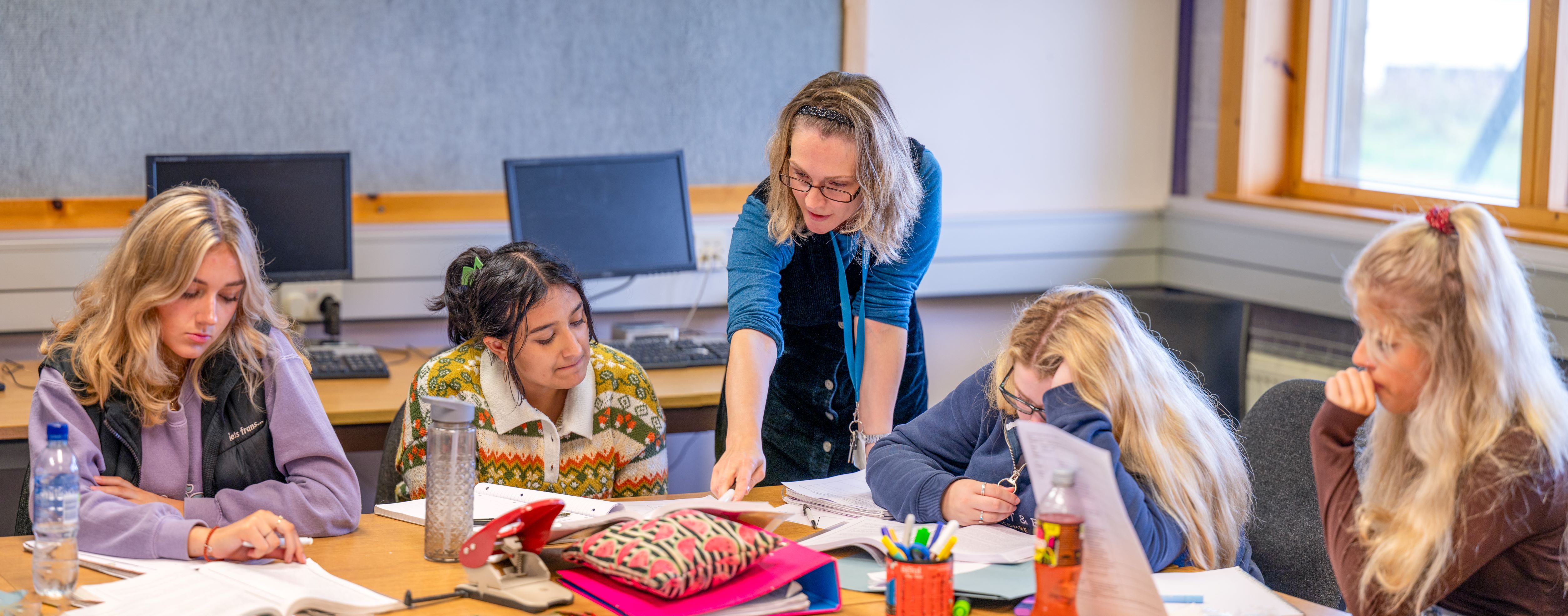 Tutor teaching three students Tutor teaching three students