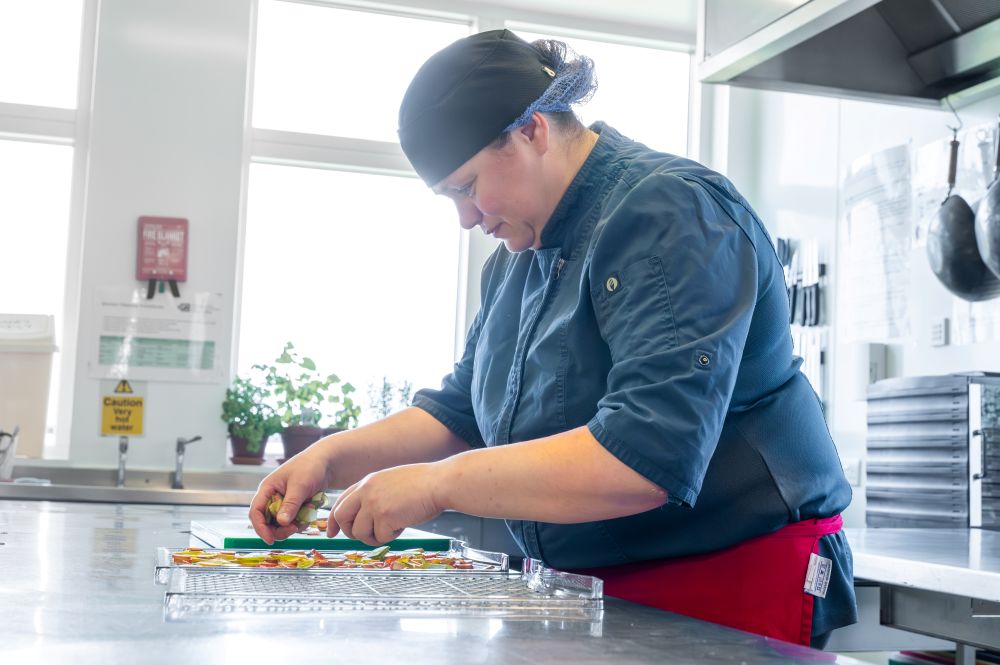 A photograph of a chef at UHI Orkney prepping food