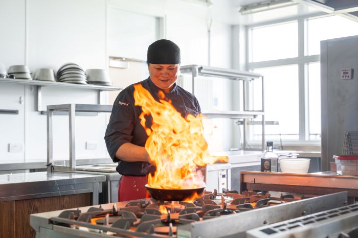 A photograph of a lecturer cooking in the hospitality department UHI Orkney
