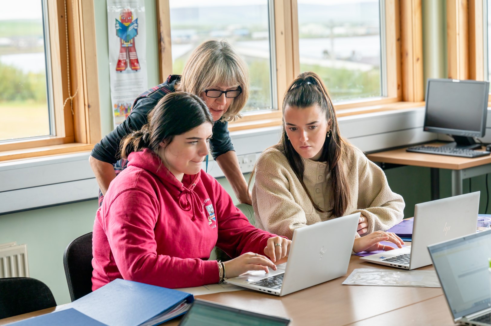 Three people looking at a laptop