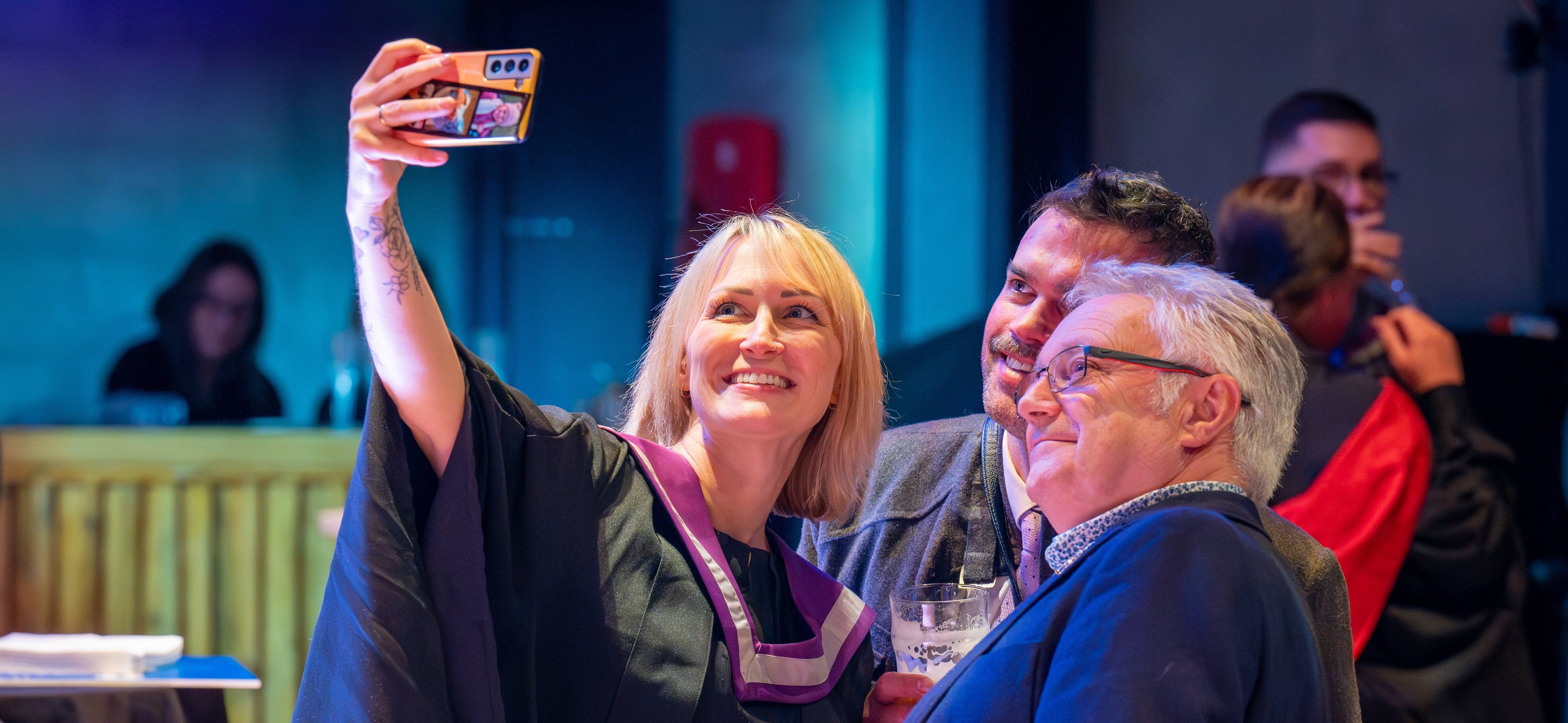 Student taking a selfie with staff Student taking a selfie with staff