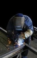 A person welding two pieces of metal.