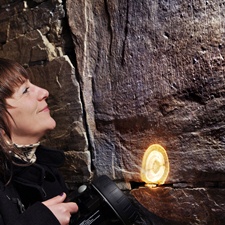 Student at Maeshowe, looking at runes